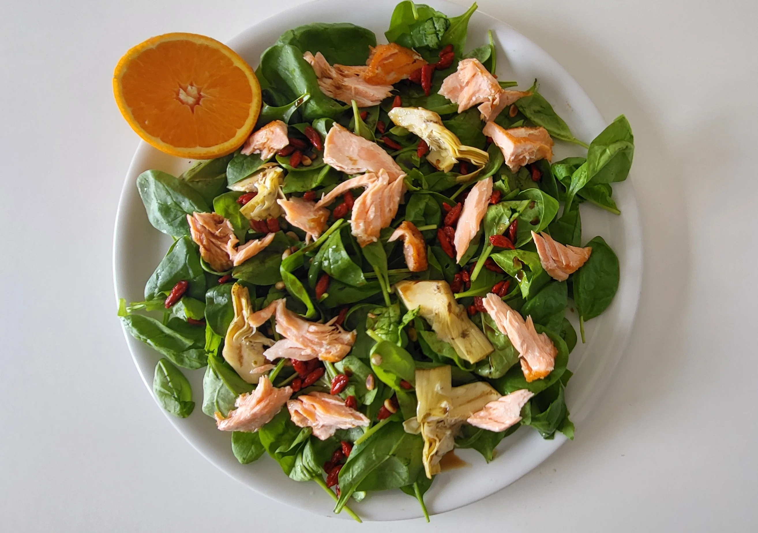 Solata iz mlade špinače z lososom, goji jagodami in balzamičnim prelivom