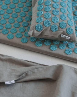 Linen acupressure mat with small pillow and pressure point discs for neck and shoulder support.