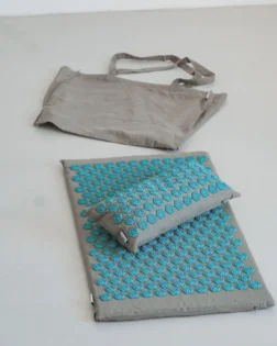 Linen acupressure mat with small pillow and pressure point discs for neck and shoulder support.