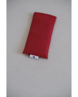 Red cotton eye pillow with flax seeds and lavender, gentle weight for relaxation.