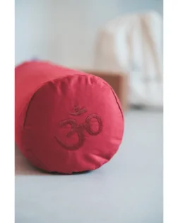 Yoga bolster rosso con pula di grano saraceno e fodera in cotone, rullo cilindrico per pratica restaurativa.