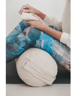 Natural linen yoga bolster with buckwheat hulls, cylindrical support for restorative yoga and pranayama.