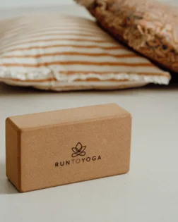 Small cork yoga block for hand support and stability in yoga poses.