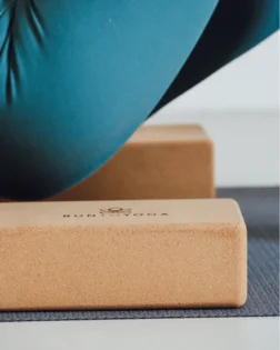Small cork yoga block for hand support and stability in yoga poses.